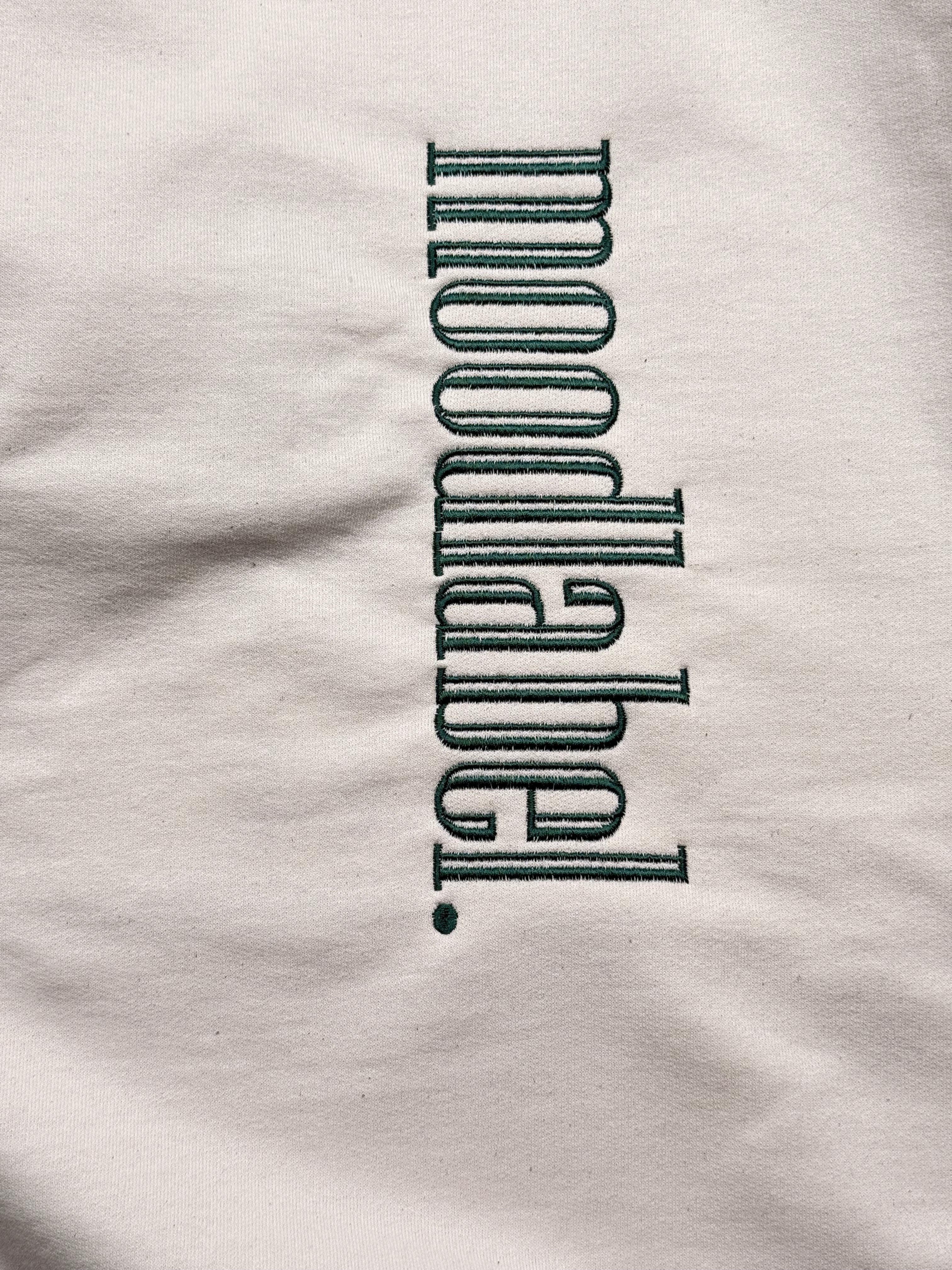 Text 'moodlabel.' on an oatmeal colored fabric background