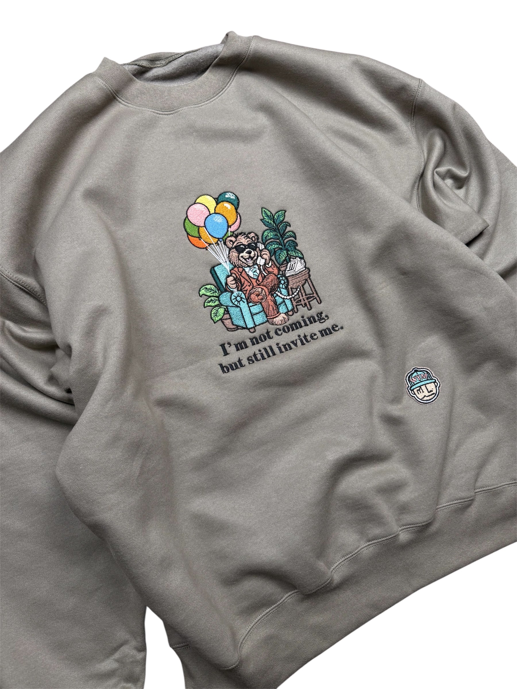 Olive sweatshirt with a graphic of a bear, balloons, and text on a white background