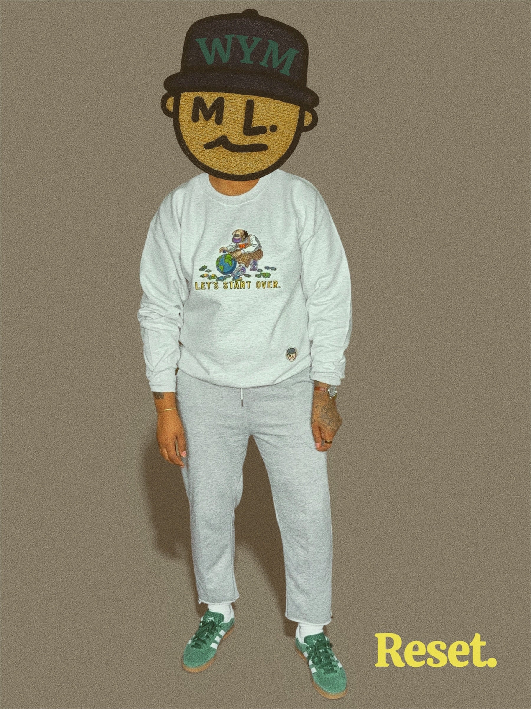 Person wearing an ash gray sweatshirt with graphics and text, standing against a beige background.